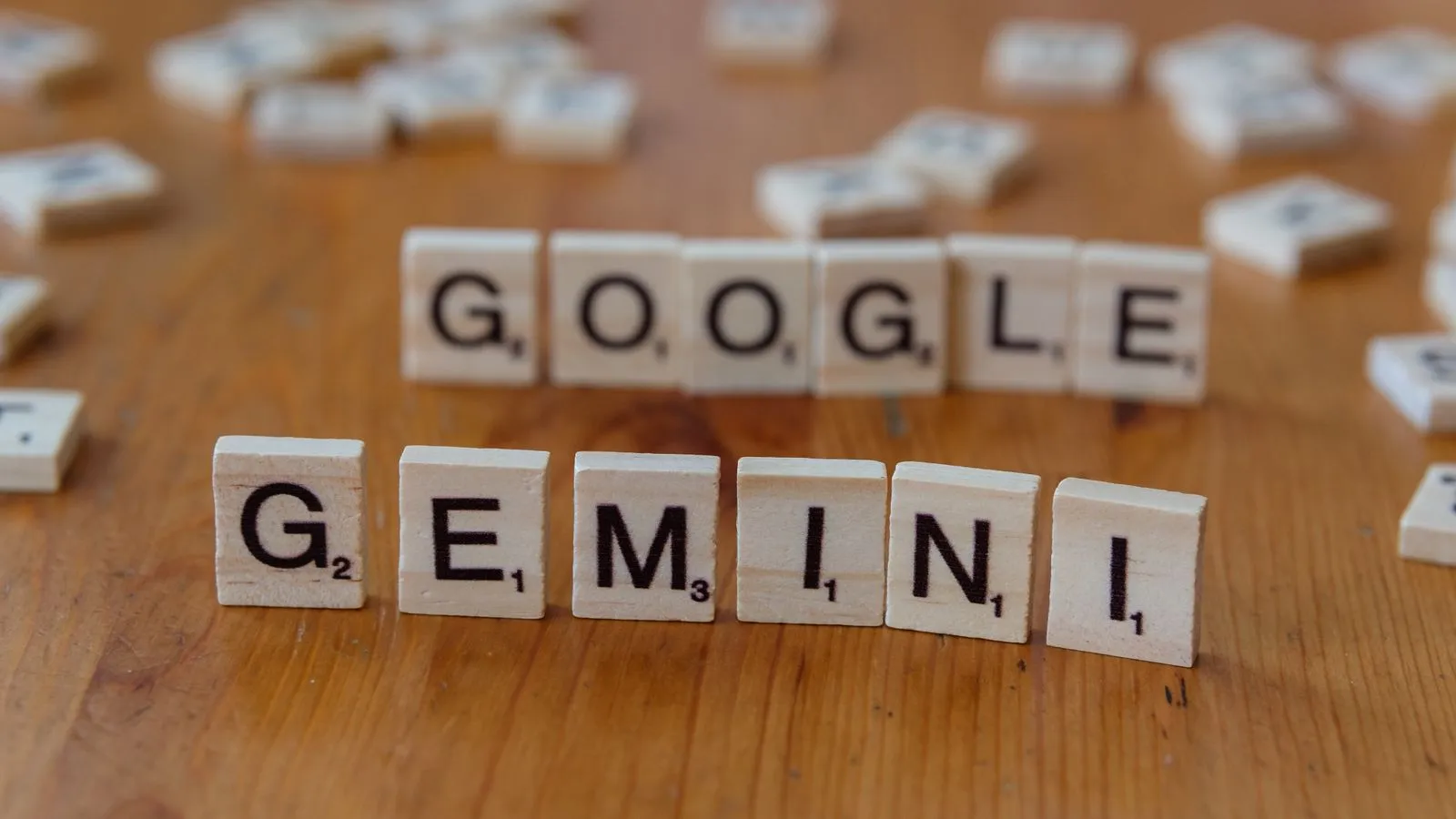 Lettres de Scrabble en bois formant les mots Google et Gemini posées sur une table