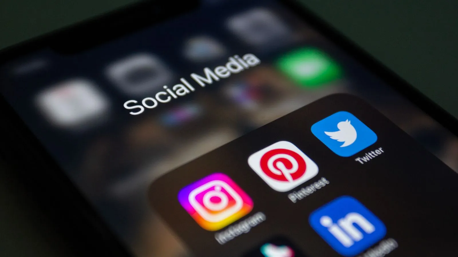 Écran de smartphone affichant un dossier « Social Media » avec les applications Instagram, Pinterest, Twitter et LinkedIn